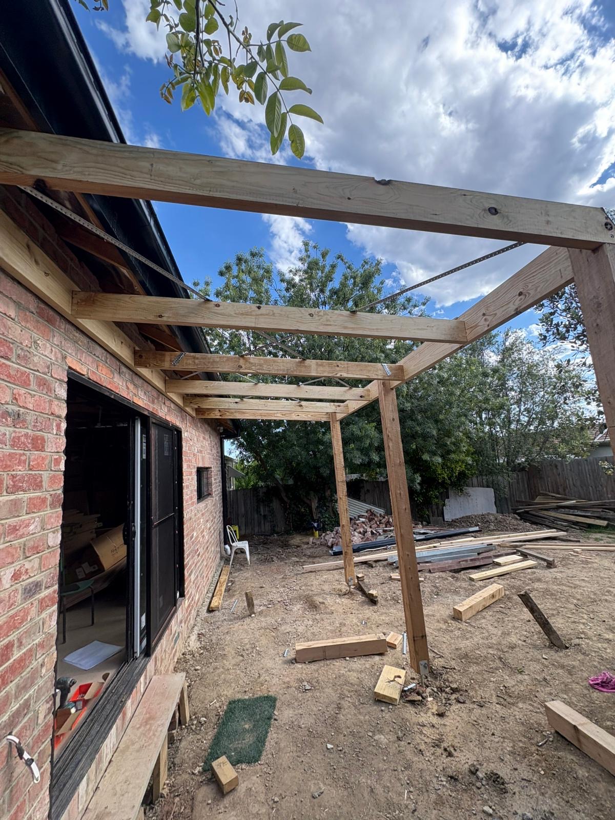 Timber pergola frame attached to brick home